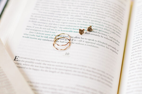 The Katelyn 14k Gold Wave Ring and The Nita 14k Gold Leopard Earrings laying on a book